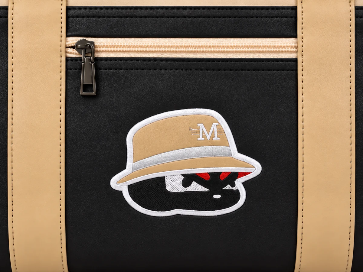 Close-up of the MONS logo patch on the Boston Bag front panel